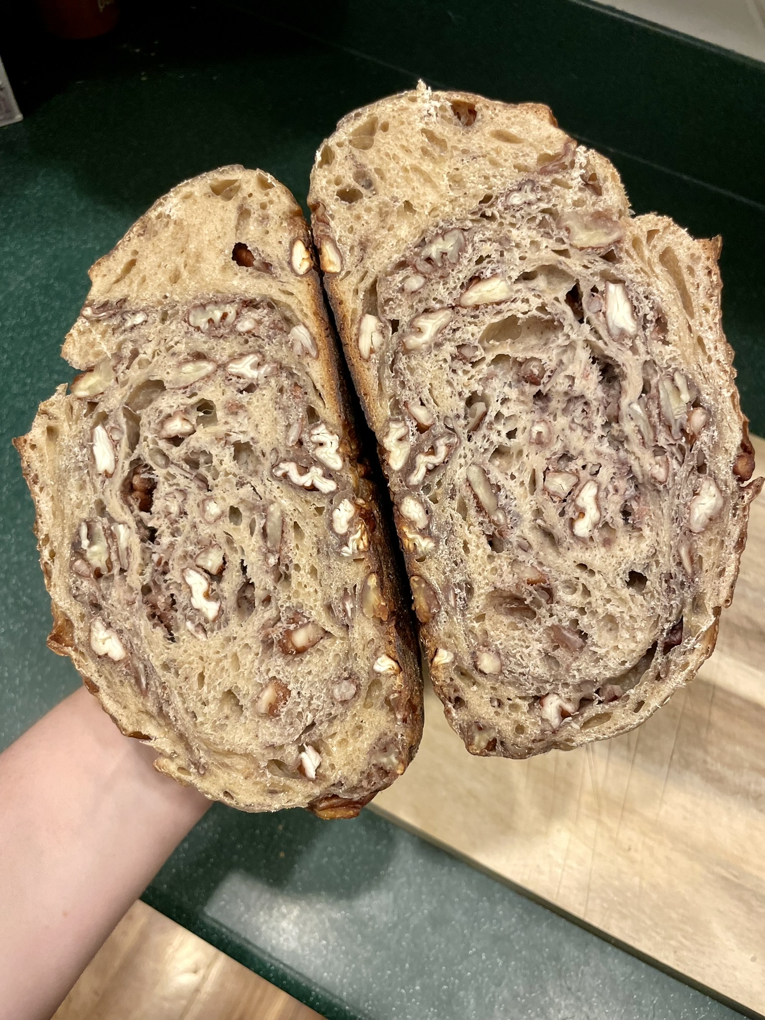 Maple nut sourdough halves held up showing nuts throughout the crumb